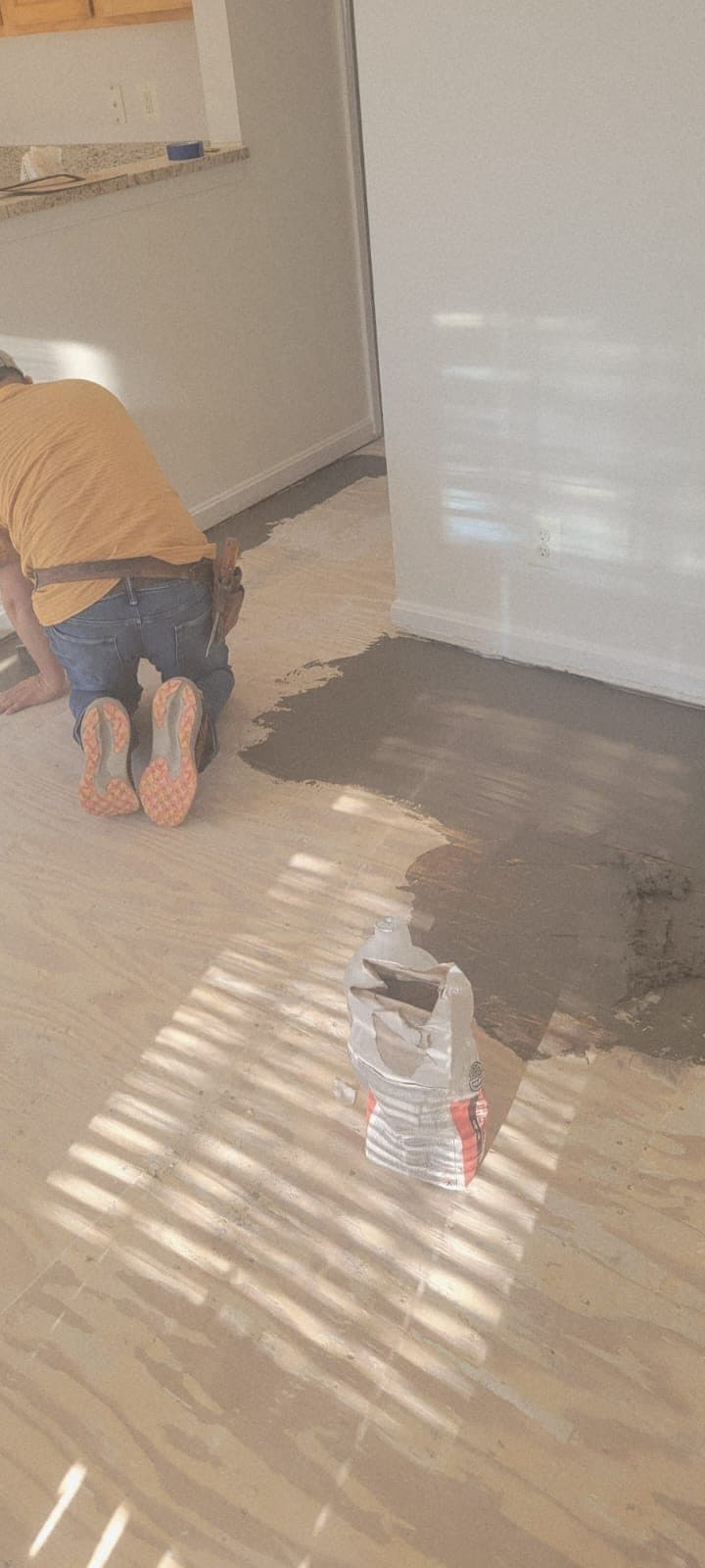 Subfloor leveling compound being applied before new flooring installation