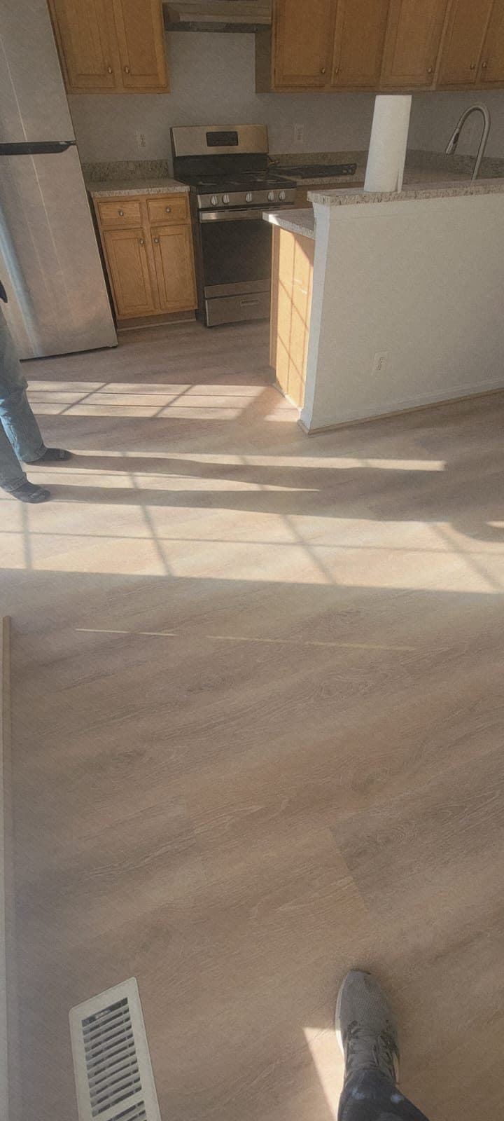 New wood-look plank flooring installed through a kitchen and dining area