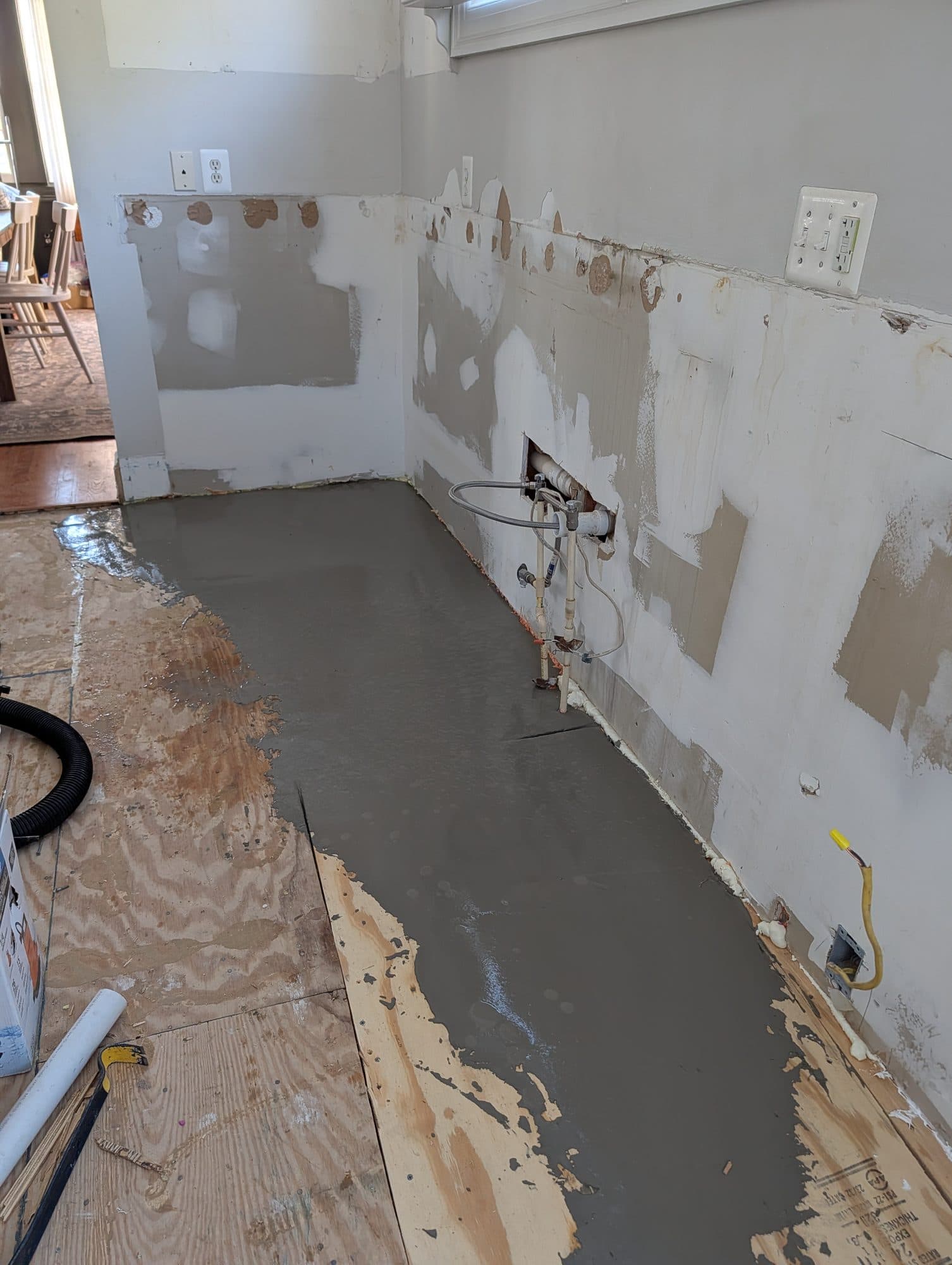Self-leveling underlayment poured near plumbing rough-in before new flooring installation